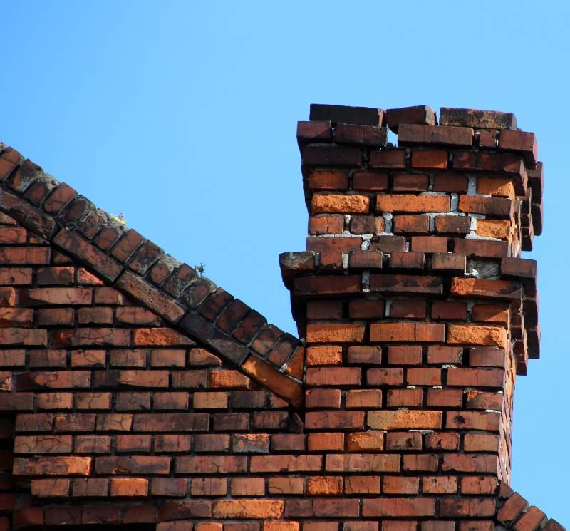 Damaged chimney on an Warrenville home showing cracks and missing mortar